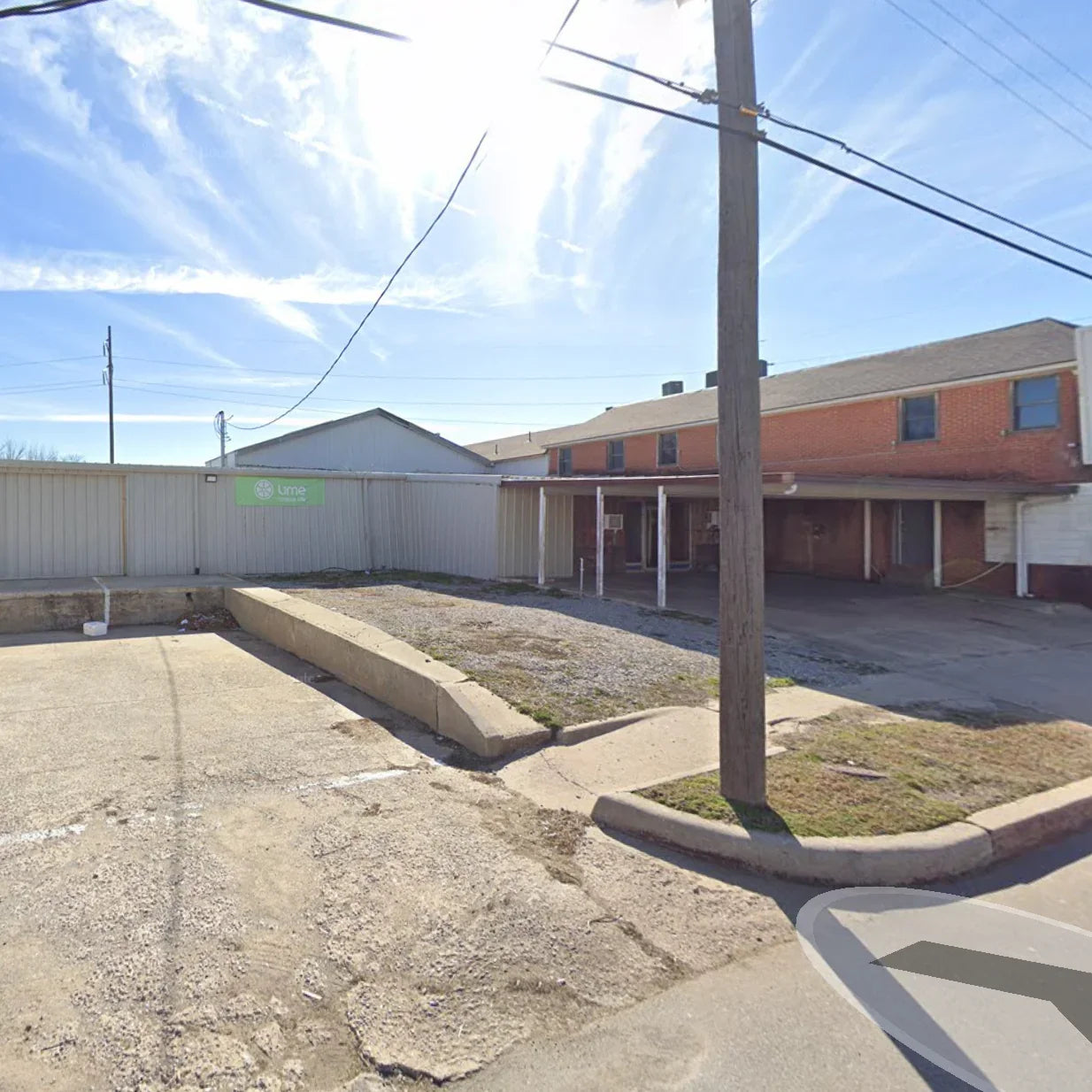 Empty street with a sidewalk and buildings in the background